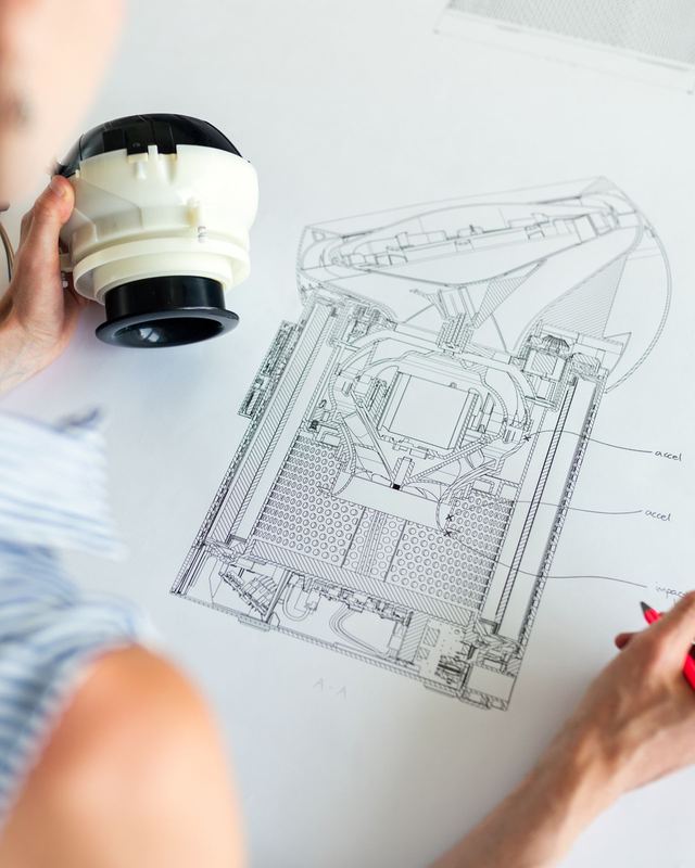Ingenieurin prüft ein Bauteil an einer technischen Zeichnung